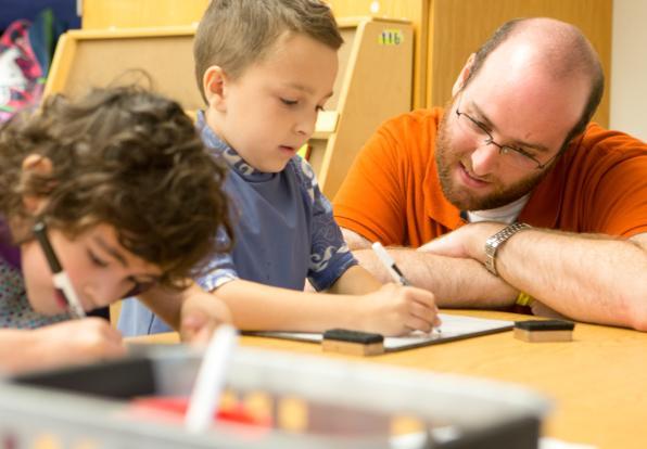 teacher helping students with assignment