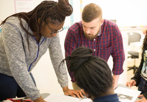 teacher with 2 students at a desk 