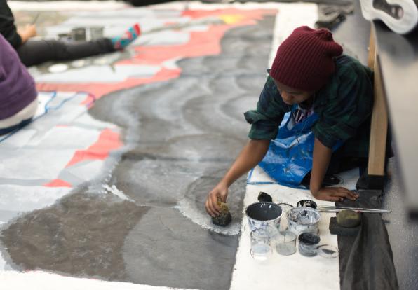 student painting a community mural