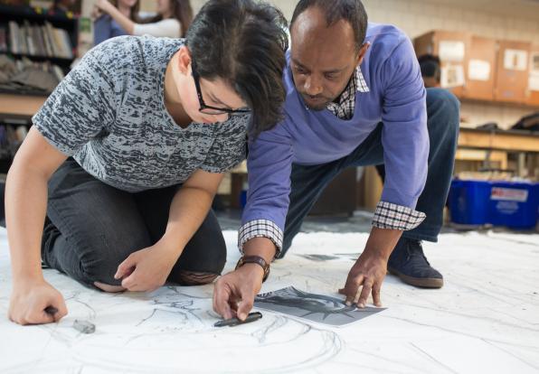 teacher helping student with art project