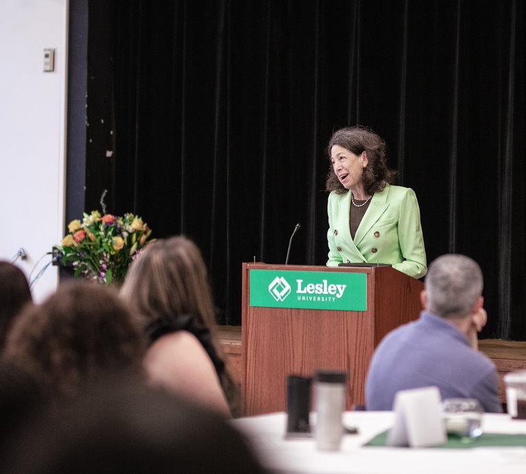 president janet steinmayer at podium speaking to people in Washurn Auditorium