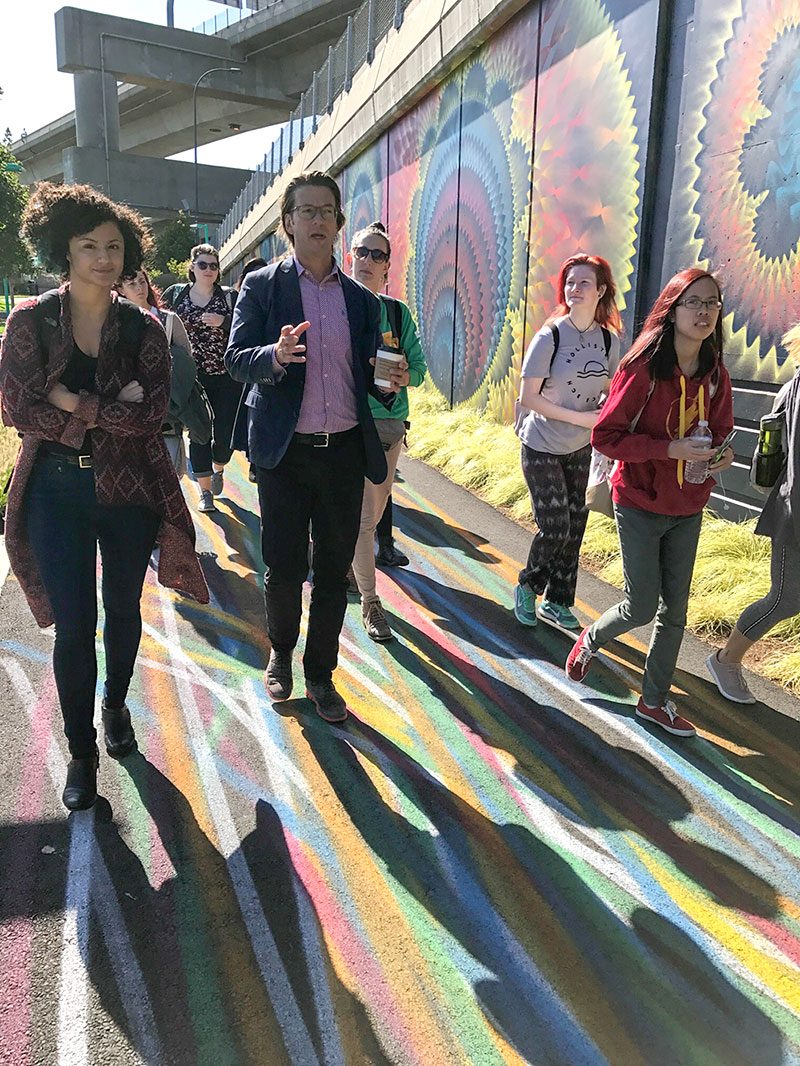 students walking along painted sidewalks and large murals